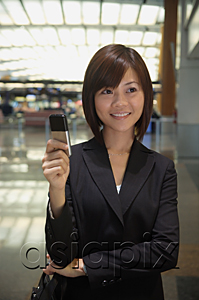 AsiaPix - Young woman with mobile phone at the airport