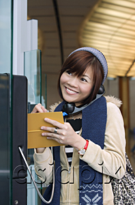 AsiaPix - Young woman on public phone at the airport