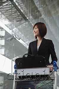 AsiaPix - Young woman smiling into distance at the airport