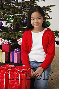 AsiaPix - Girl with Christmas presents and Christmas tree at background