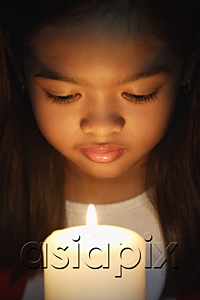 AsiaPix - Girl holding and looking at candle
