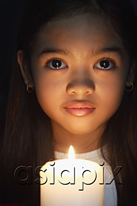 AsiaPix - Girl holding candle looking at camera