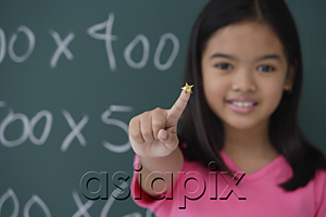 AsiaPix - Girl with star on finger standing in front of blackboard