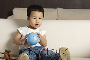 AsiaPix - Baby boy holding globe looking at camera