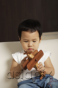 AsiaPix - Baby boy playing with wooden toy plane