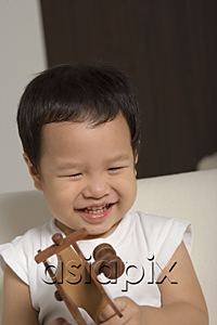 AsiaPix - Baby boy playing with wooden toy plane