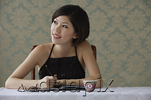 AsiaPix - Young woman looking sideways while writing