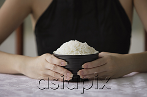 AsiaPix - Young woman holding bowl of rice with both hands