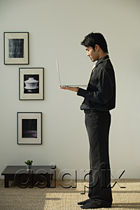 AsiaPix - Young man holding laptop