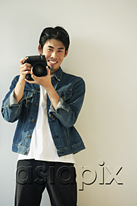 AsiaPix - Young man with camera on hands, smiling at camera