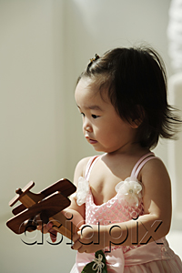 AsiaPix - Baby girl with toy plane in hands
