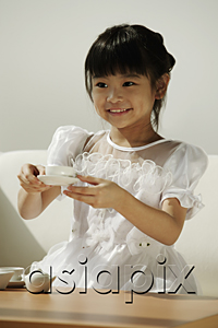 AsiaPix - Girl in white dress playing with tea cups