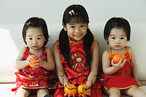 AsiaPix - Girls with mandarin oranges sitting on sofa