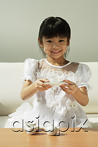 AsiaPix - Girl with tea set in hands smiling at camera