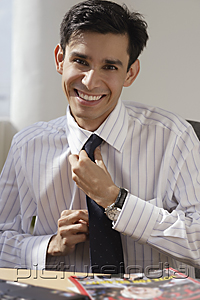 PictureIndia - A man smiles as he adjusts his tie
