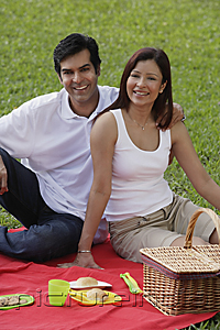PictureIndia - A couple smile at the camera as they have a picnic together in the park