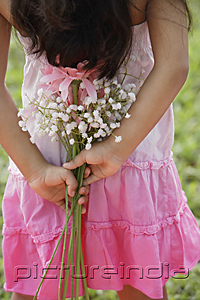 PictureIndia - A small girl holds flowers behind her back