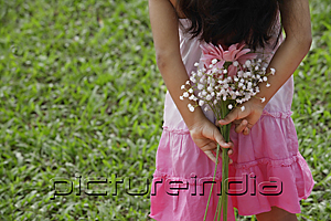 PictureIndia - A small girl holds flowers behind her back