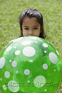 PictureIndia - A small girl plays with a green ball