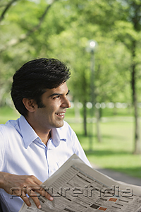 PictureIndia - A man reads the newspaper in the park