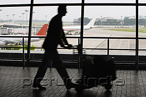 PictureIndia - Man pushing trolley at airport