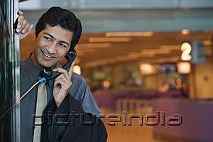 PictureIndia - Man talking on pay phone