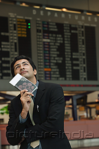 PictureIndia - Man holding passport on his chin in the airport