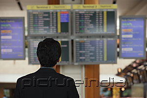 PictureIndia - Man reading departure table at airport