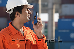 PictureIndia - Man in work uniform using walkie talkie