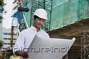 PictureIndia - Man with helmet, looking at plans