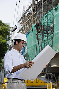 PictureIndia - Man smiling while looking at plans