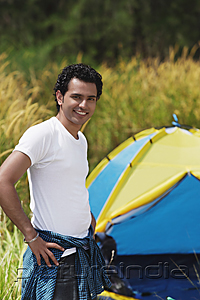 PictureIndia - Young man camping smiling at camera