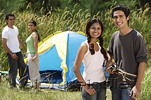 PictureIndia - Young friends camping in the wilderness, smiling at camera