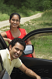 PictureIndia - Young couple with car smiling at camera