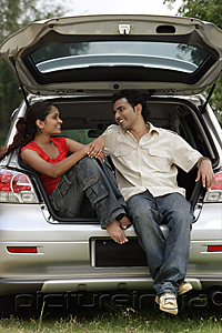 PictureIndia - Young couple sitting in car boot
