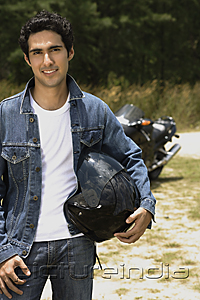 PictureIndia - Young man with motorcycle helmet smiling at camera