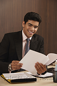 PictureIndia - Businessman reading paper and smiling