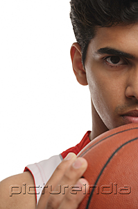 PictureIndia - Young man with basketball looking at camera