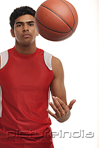 PictureIndia - Young man with basketball looking at camera
